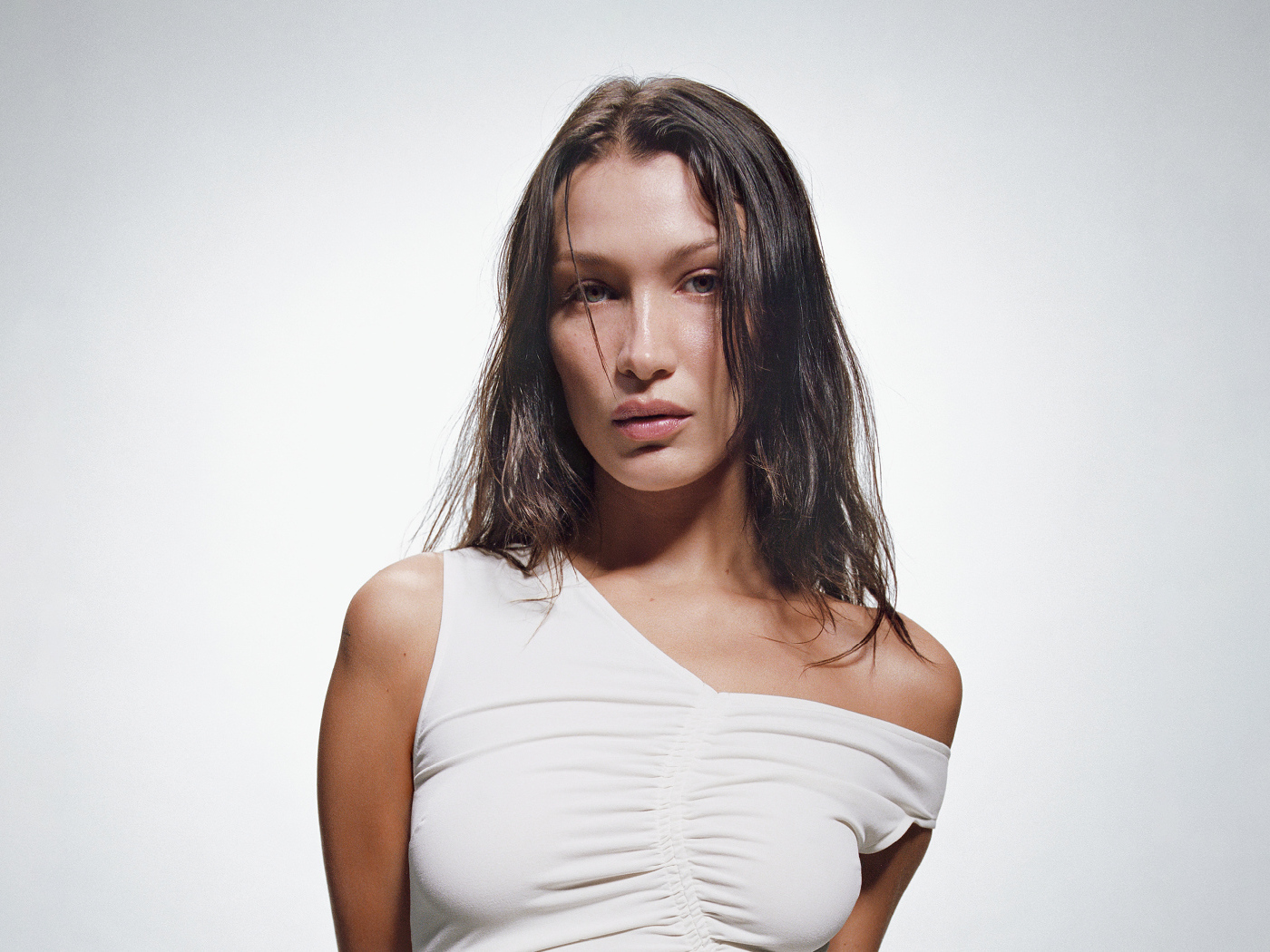 Модель Белла Хадид в белом платье на сером фоне