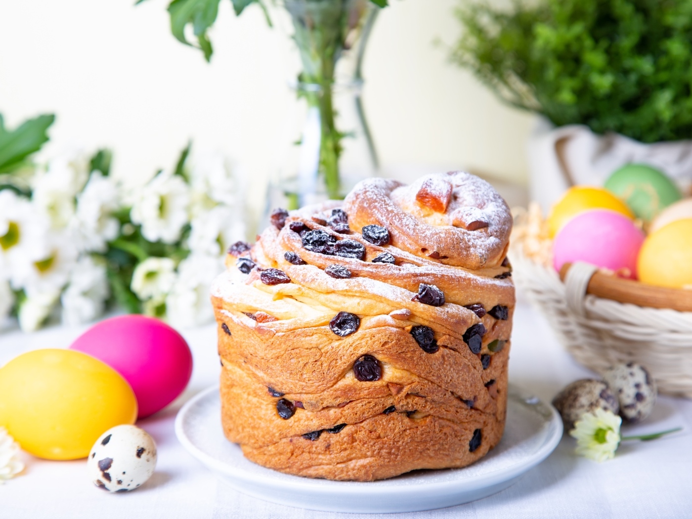 Красивый пасхальный кулич с сахарной пудрой и изюмом