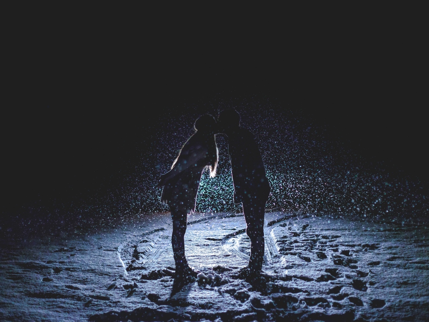 Поцелуй влюбленной пары на снегу ночью