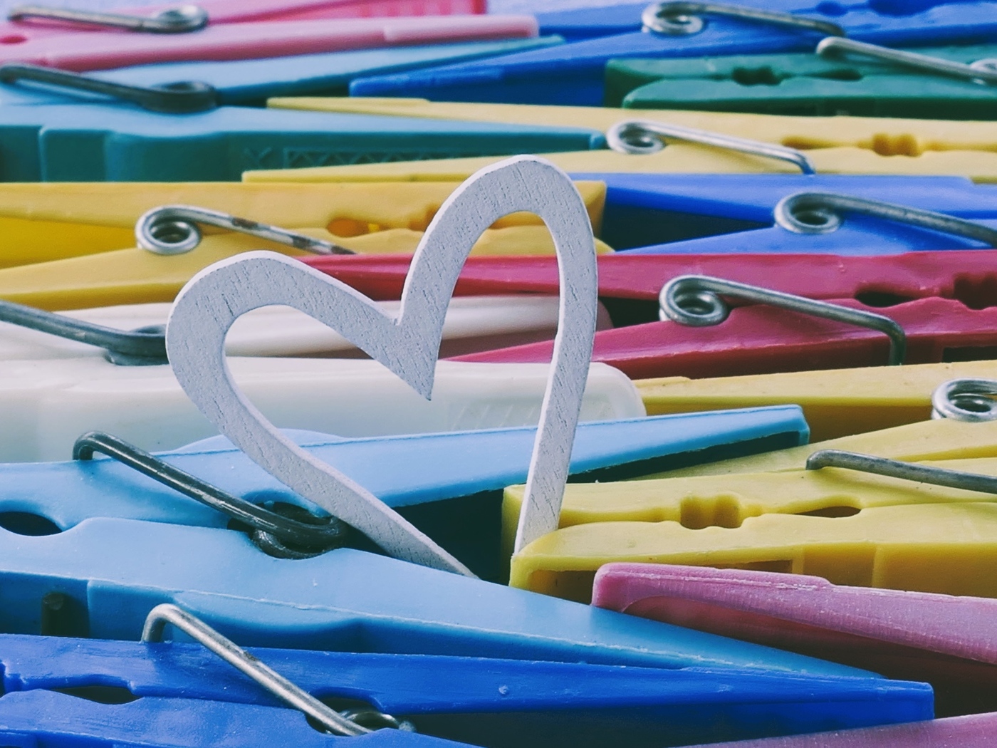 Белое деревянное сердце с разноцветными прищепками