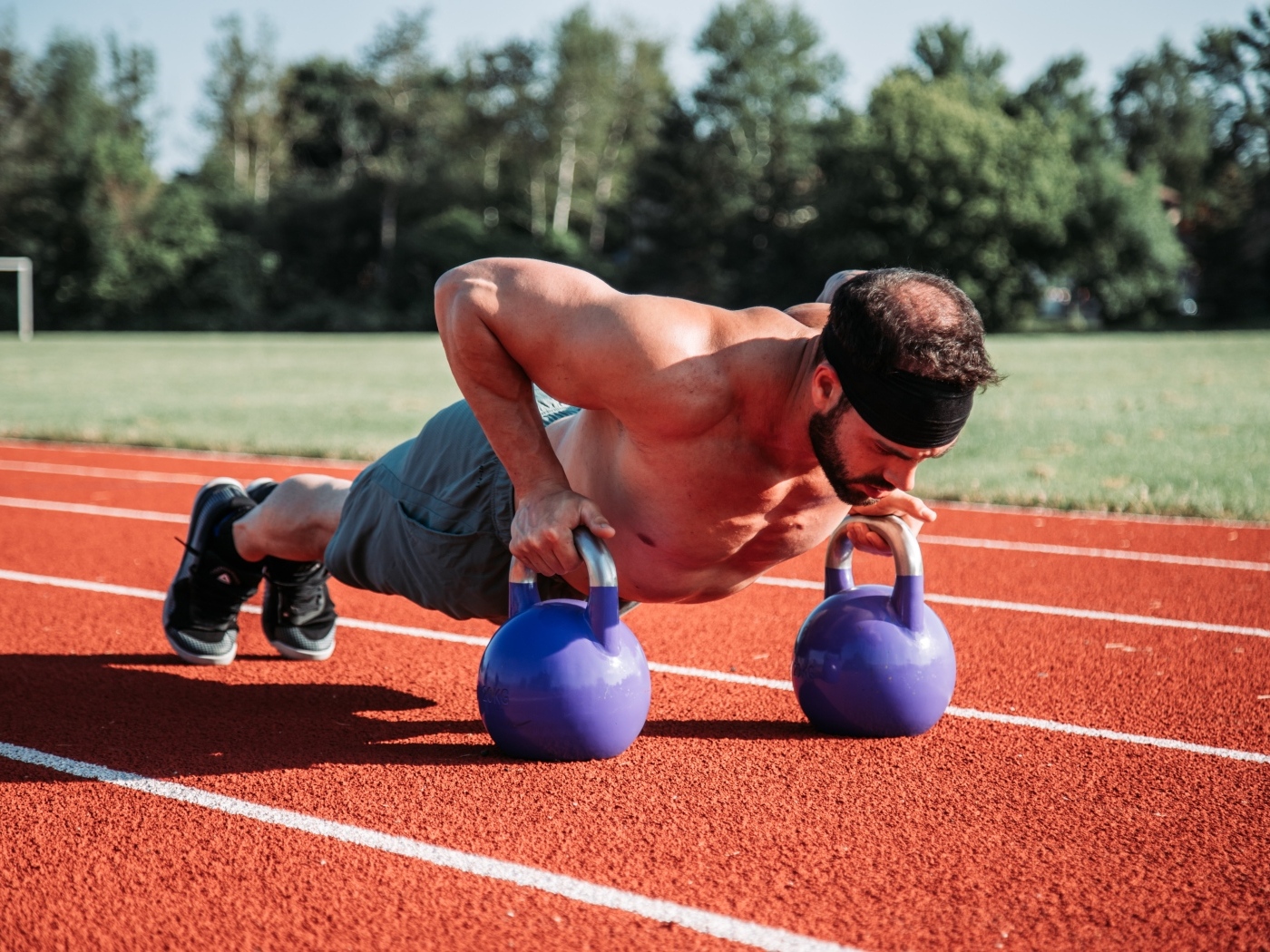 Мужчина спортсмен занимается с гирями