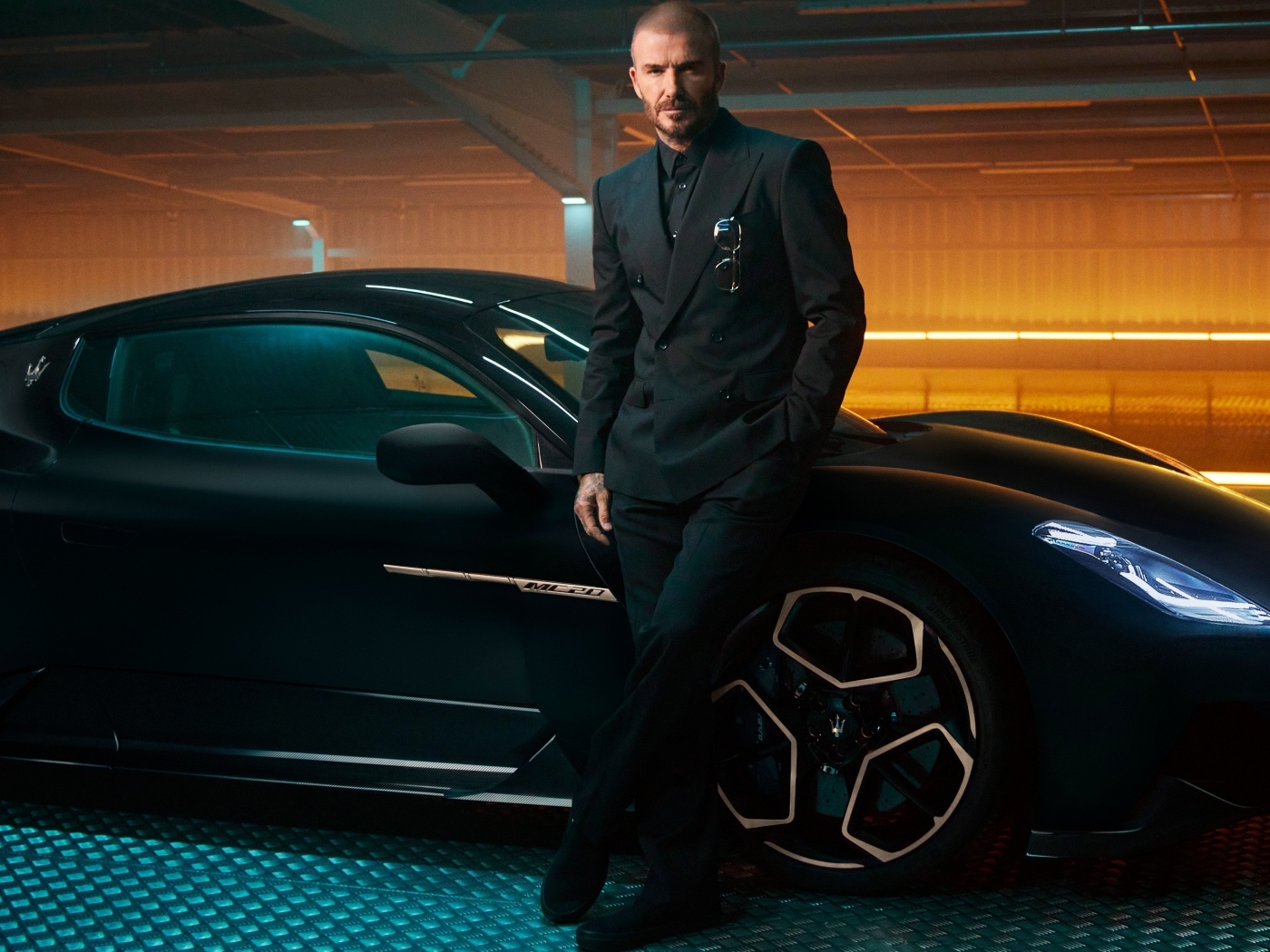 Футболист Дэвид Бекхэм у черного автомобиля Maserati MC20