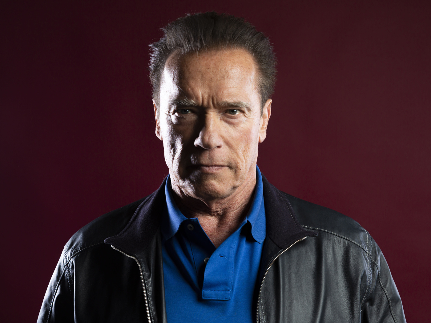 Популярный актер Арнольд Шварценеггер на красном фоне