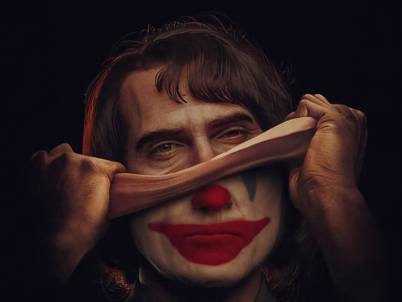 Джокер снимает маску на черном фоне