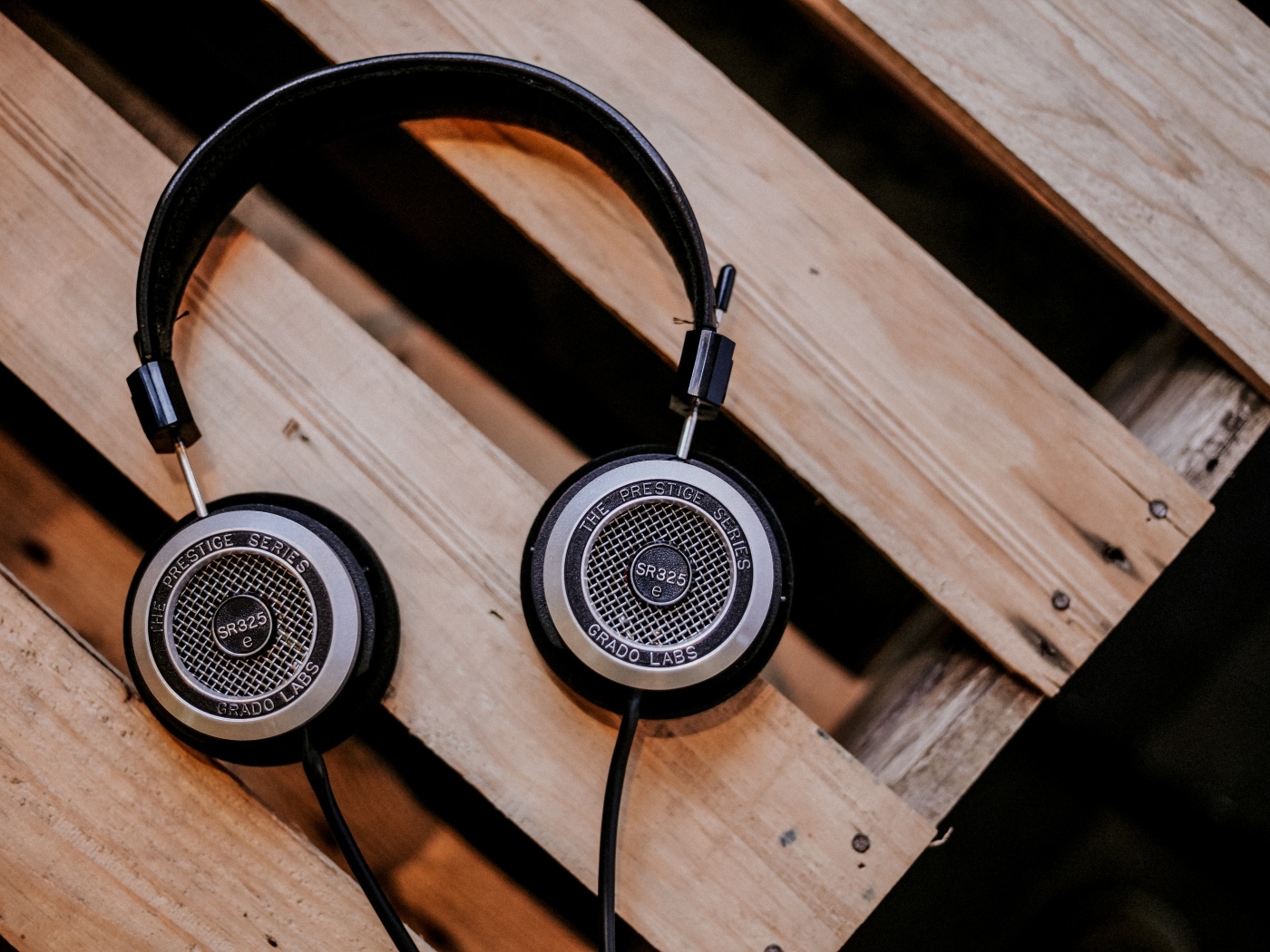 Старые наушники лежат на деревянной лавке