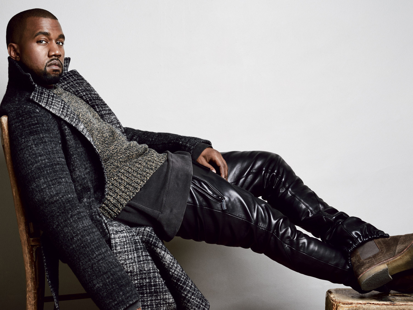 Рэпер Канье Уэст сидит на стуле