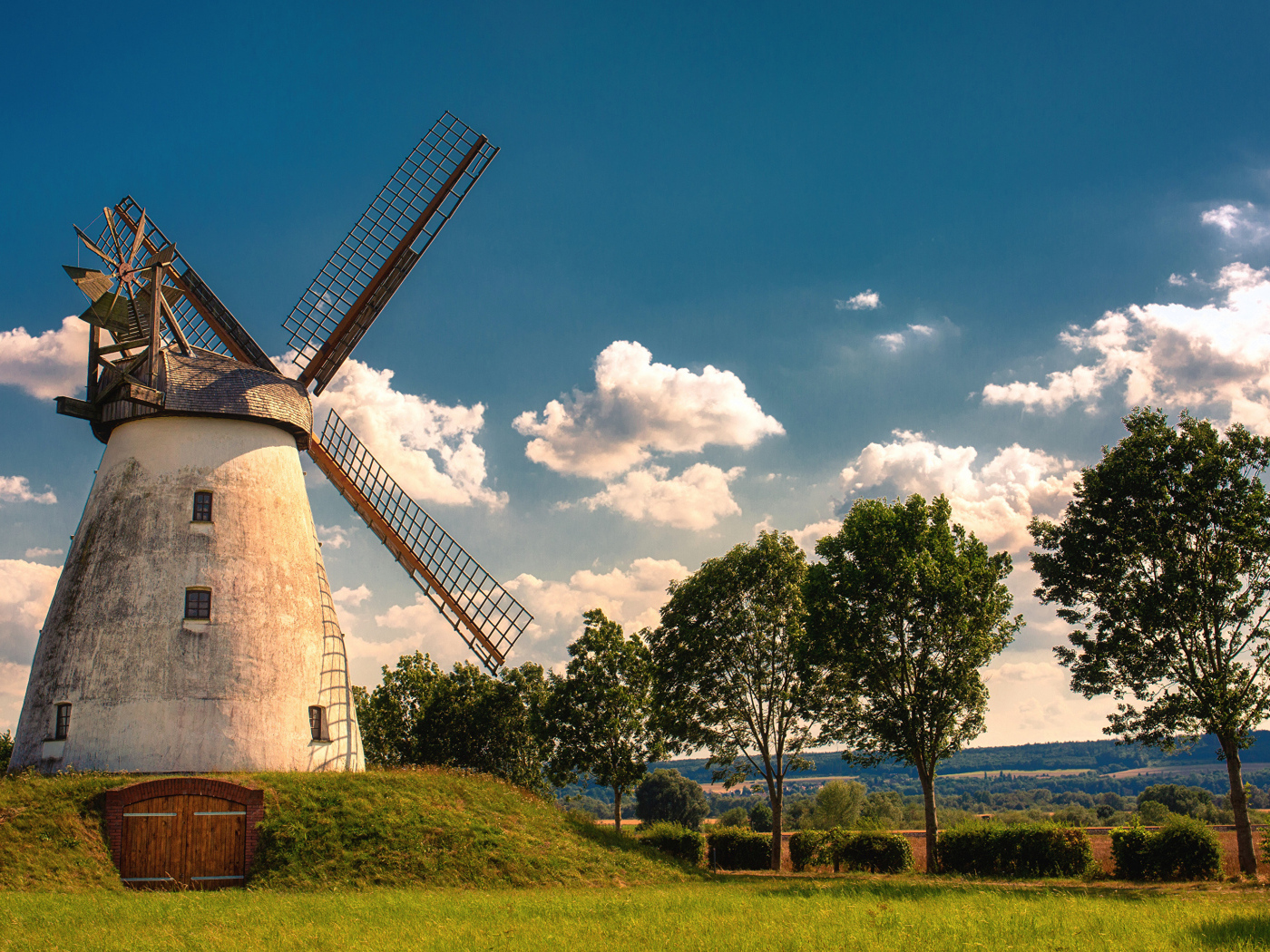Старая мельница с зелеными деревьями