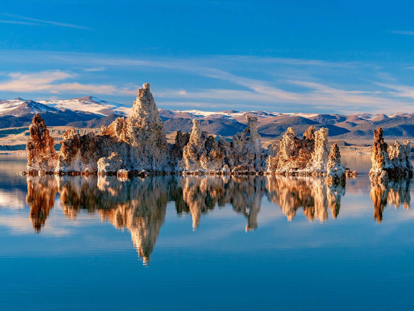 Острые скалы отражаются в тихой воде озера