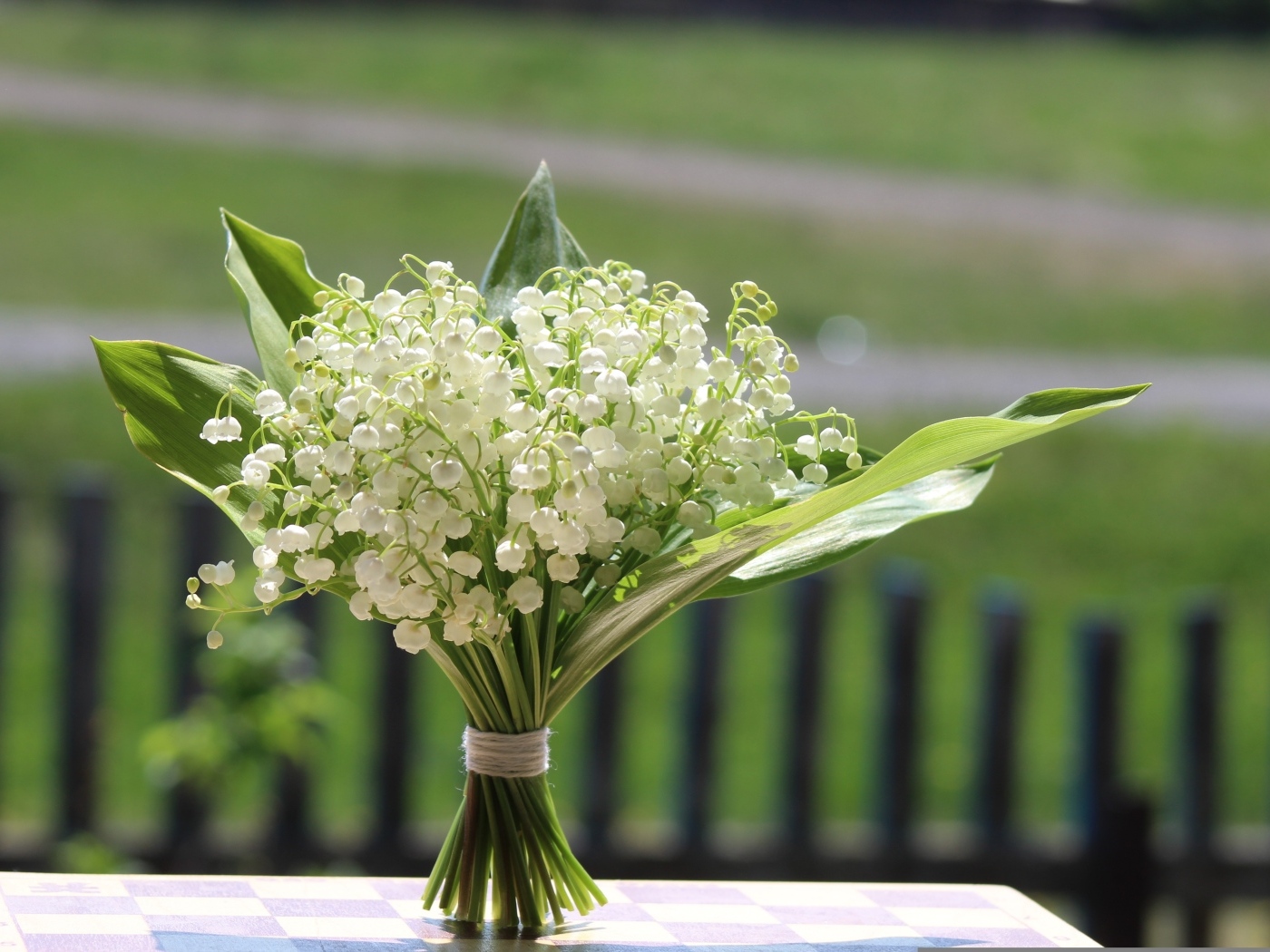 Красивый букет белых ландышей на столе в вазе