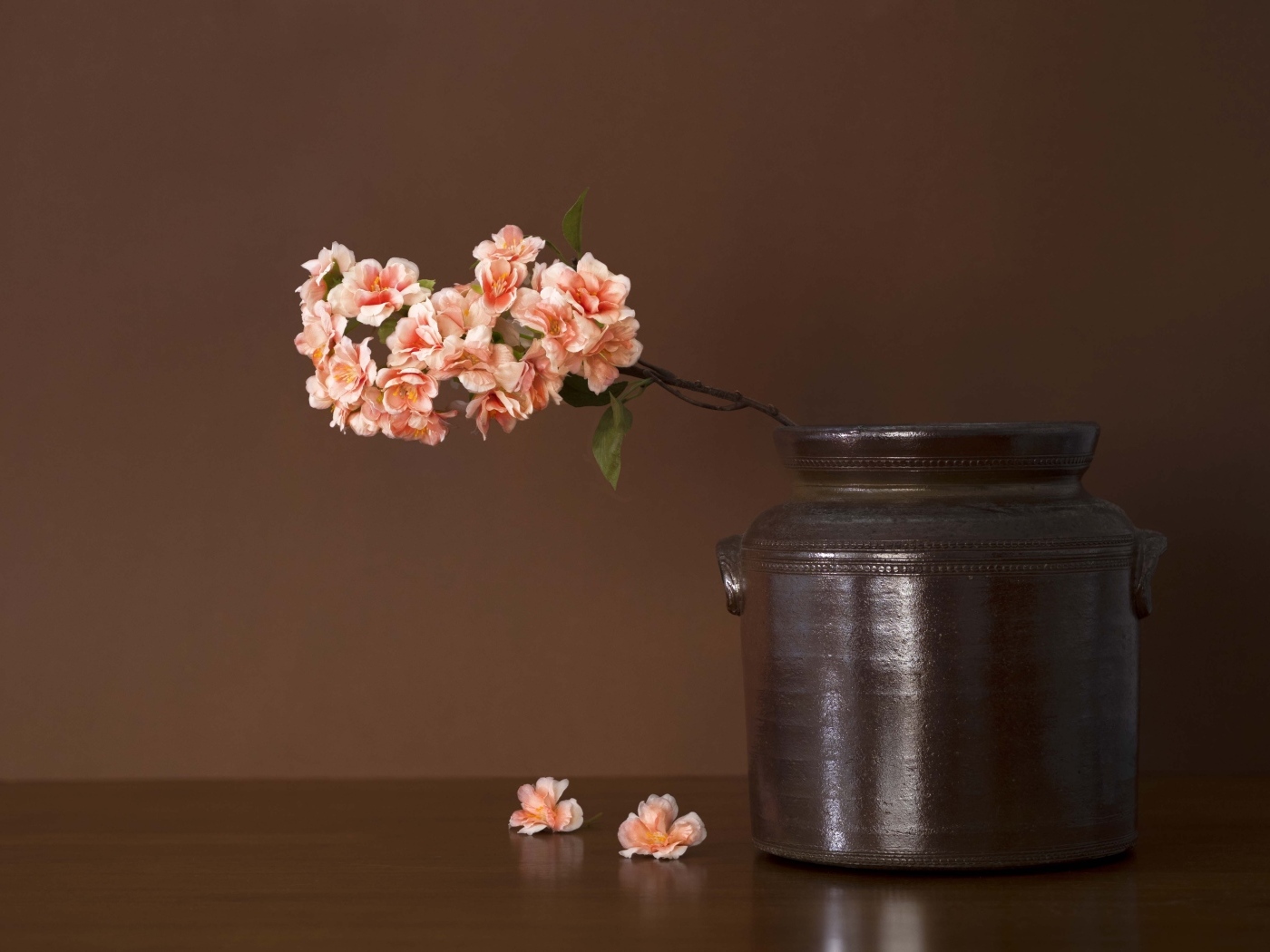 Ветка с розовыми цветами в вазе на столе