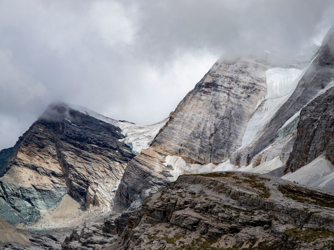 Высокие каменные горы в белых облаках