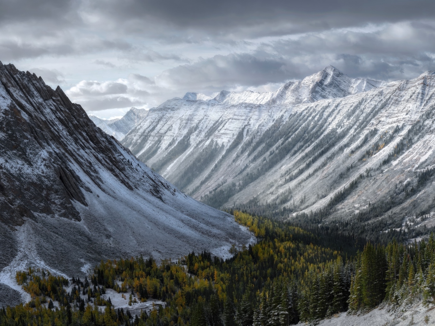 Покрытые снегом горы под грозовым небом