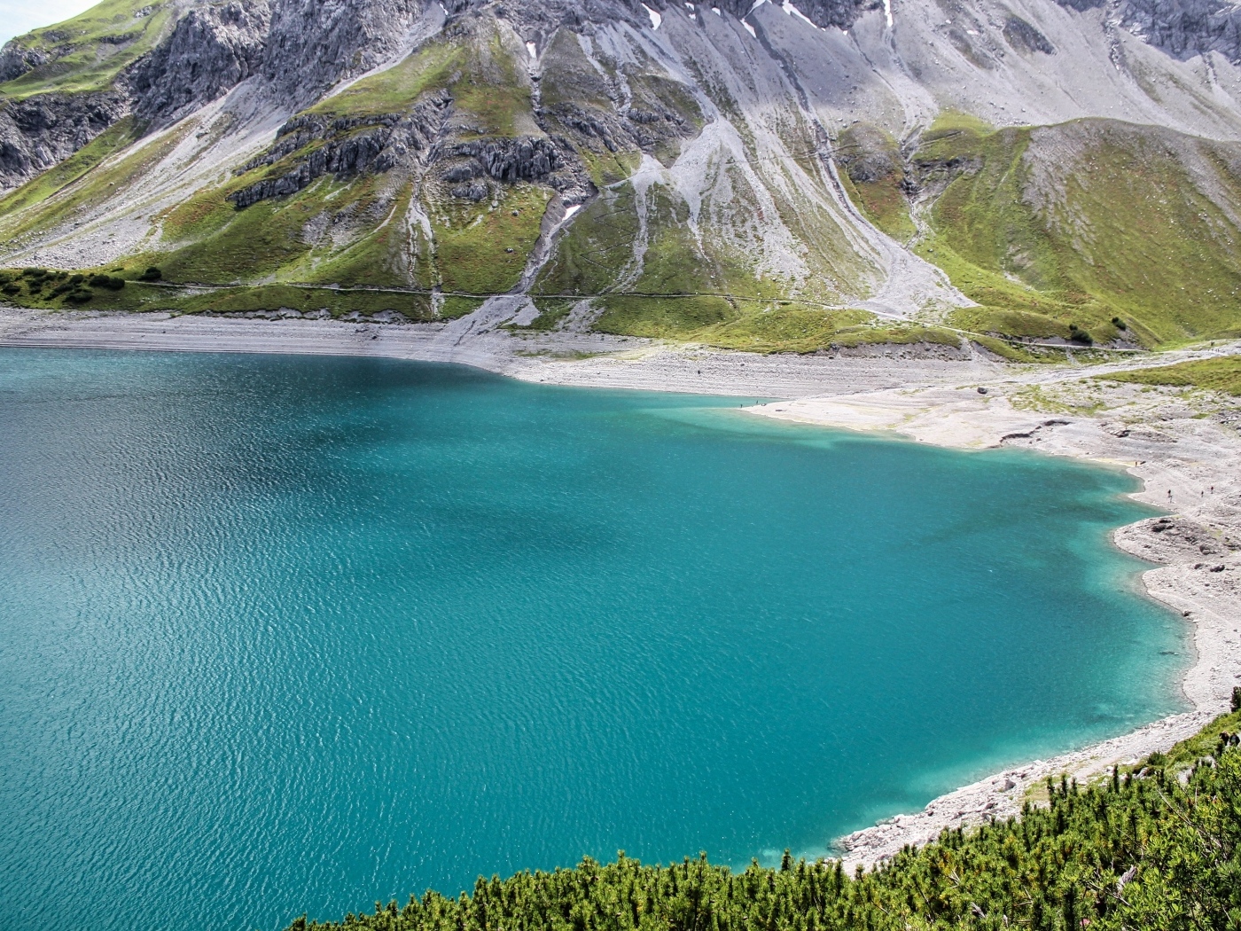 Чистая голубая вода в озере у высоких гор 