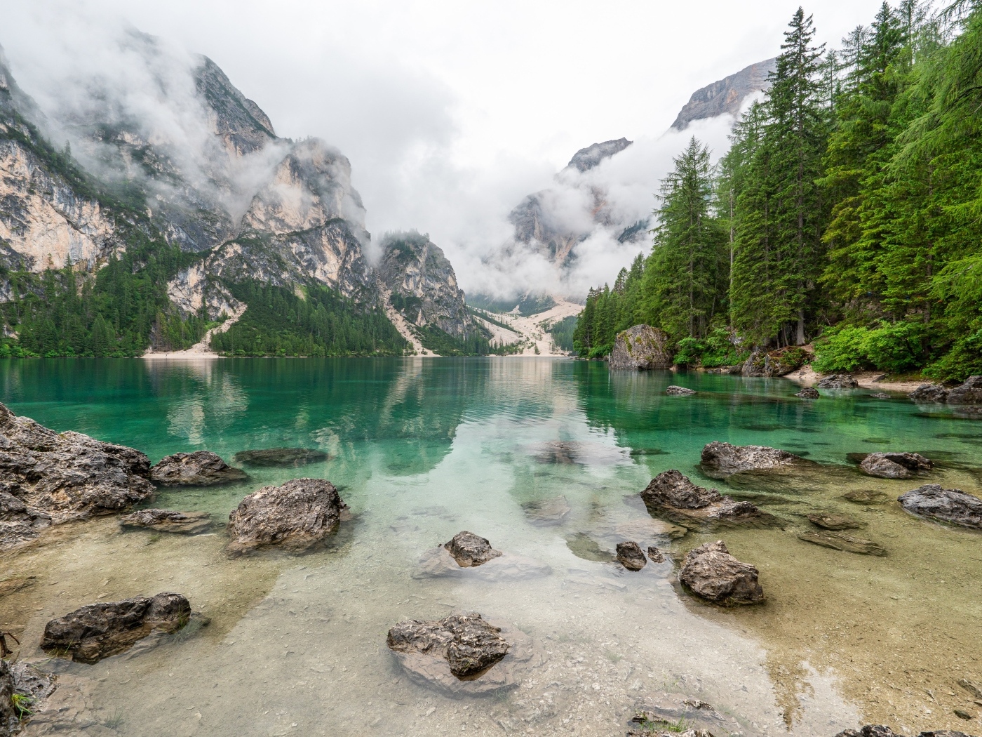 Камни лежат в воде озера в холодных горах
