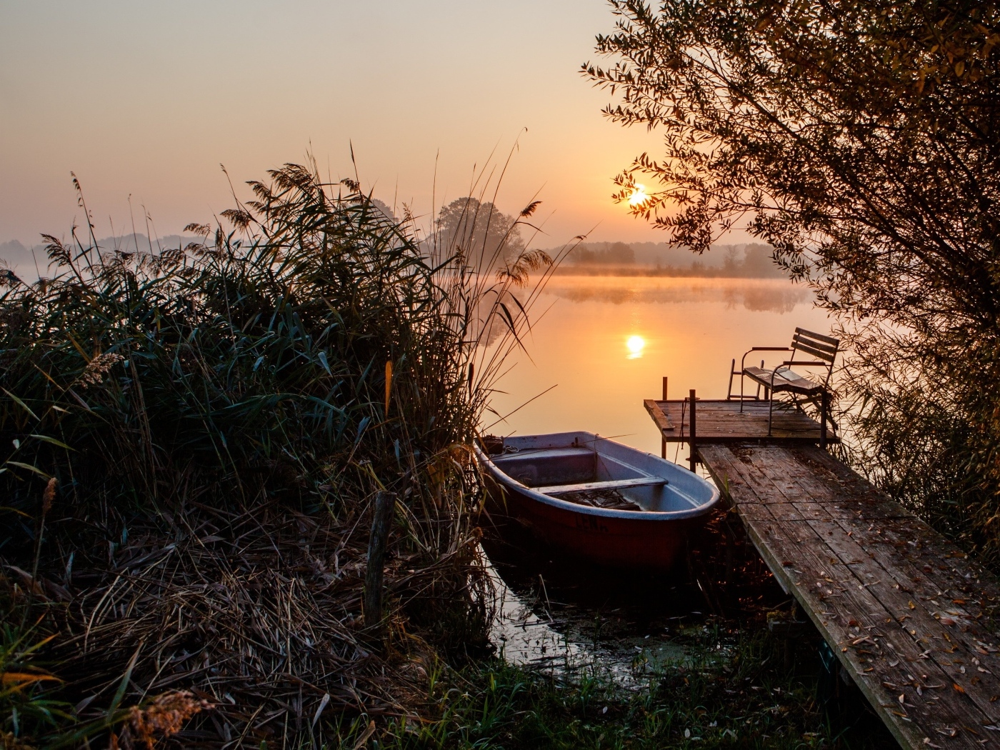 Лодка на берегу озера на закате 