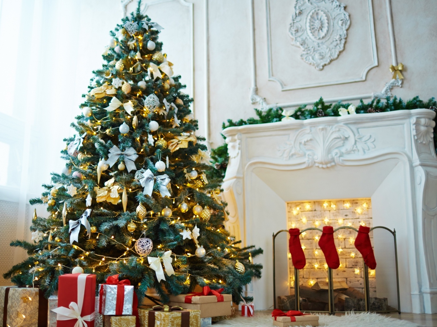 Красивая наряженная ель в комнате с камином