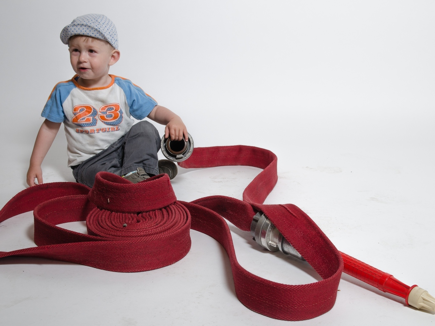 Мальчик с красным пожарным шлангом