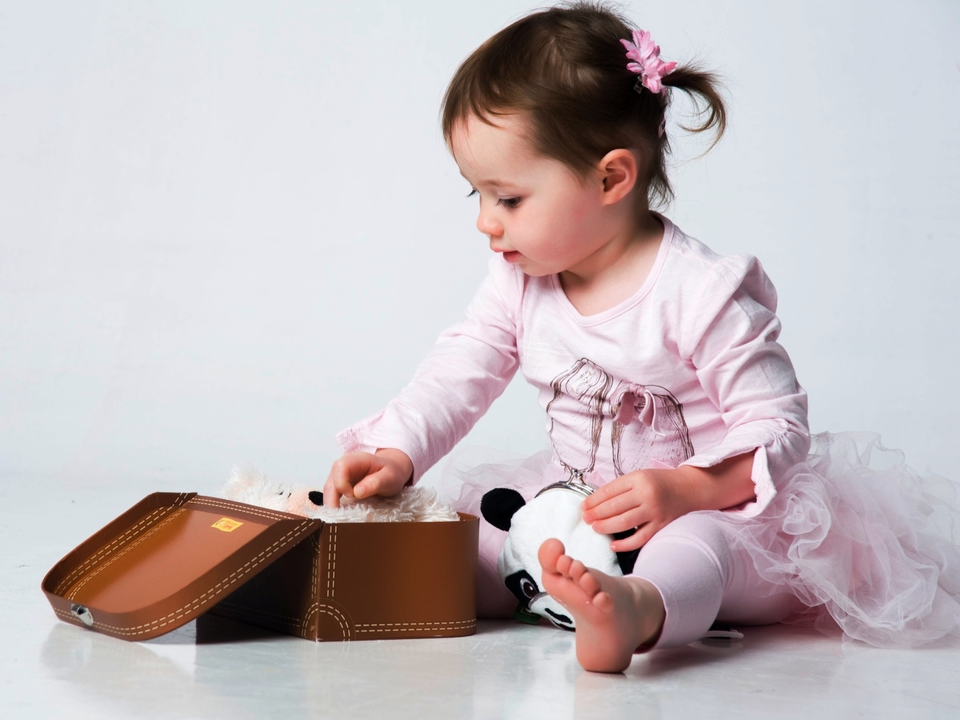 Девочка в розовом наряде с маленьким чемоданом