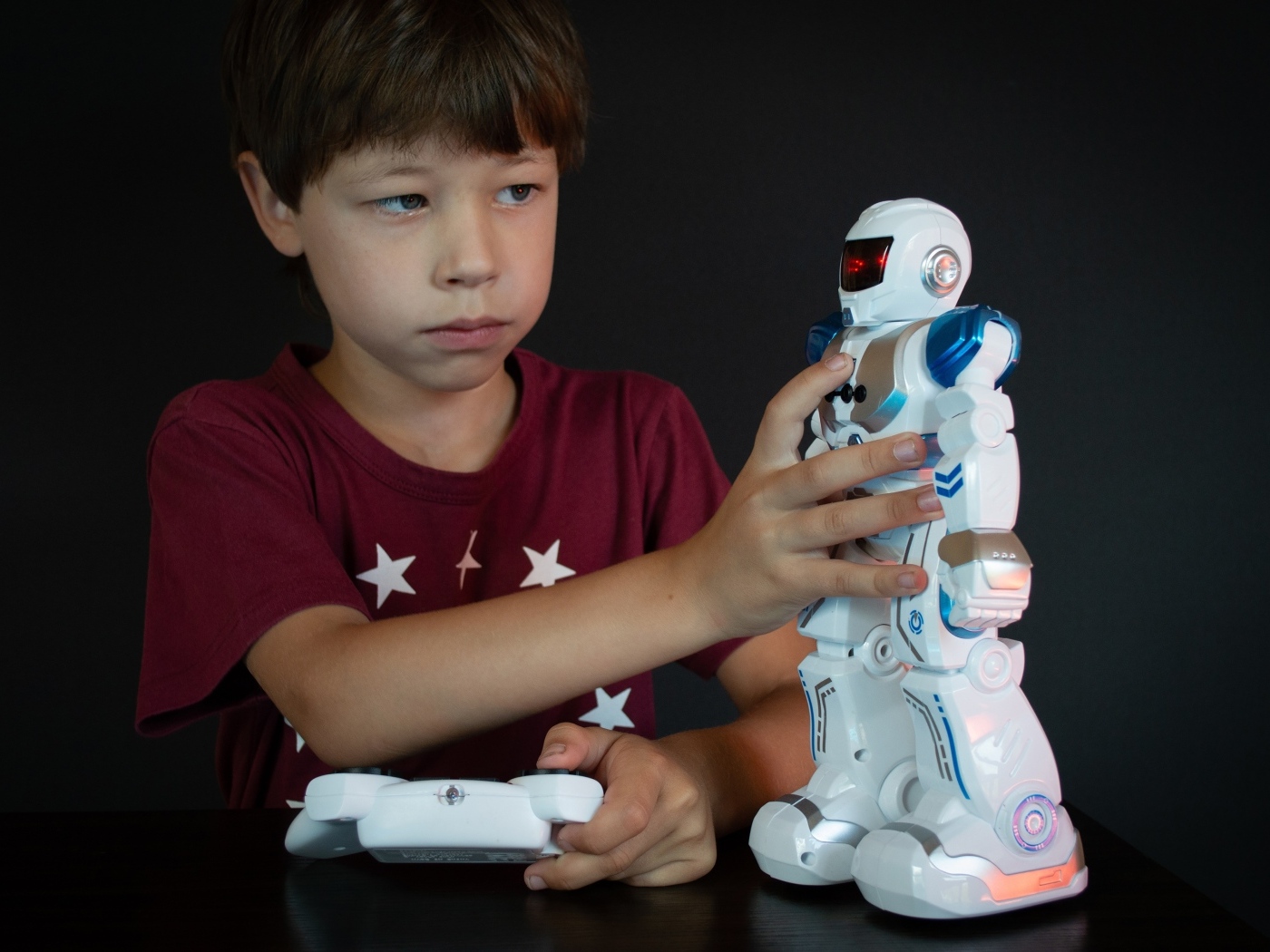 Маленький мальчик с роботом на черном фоне