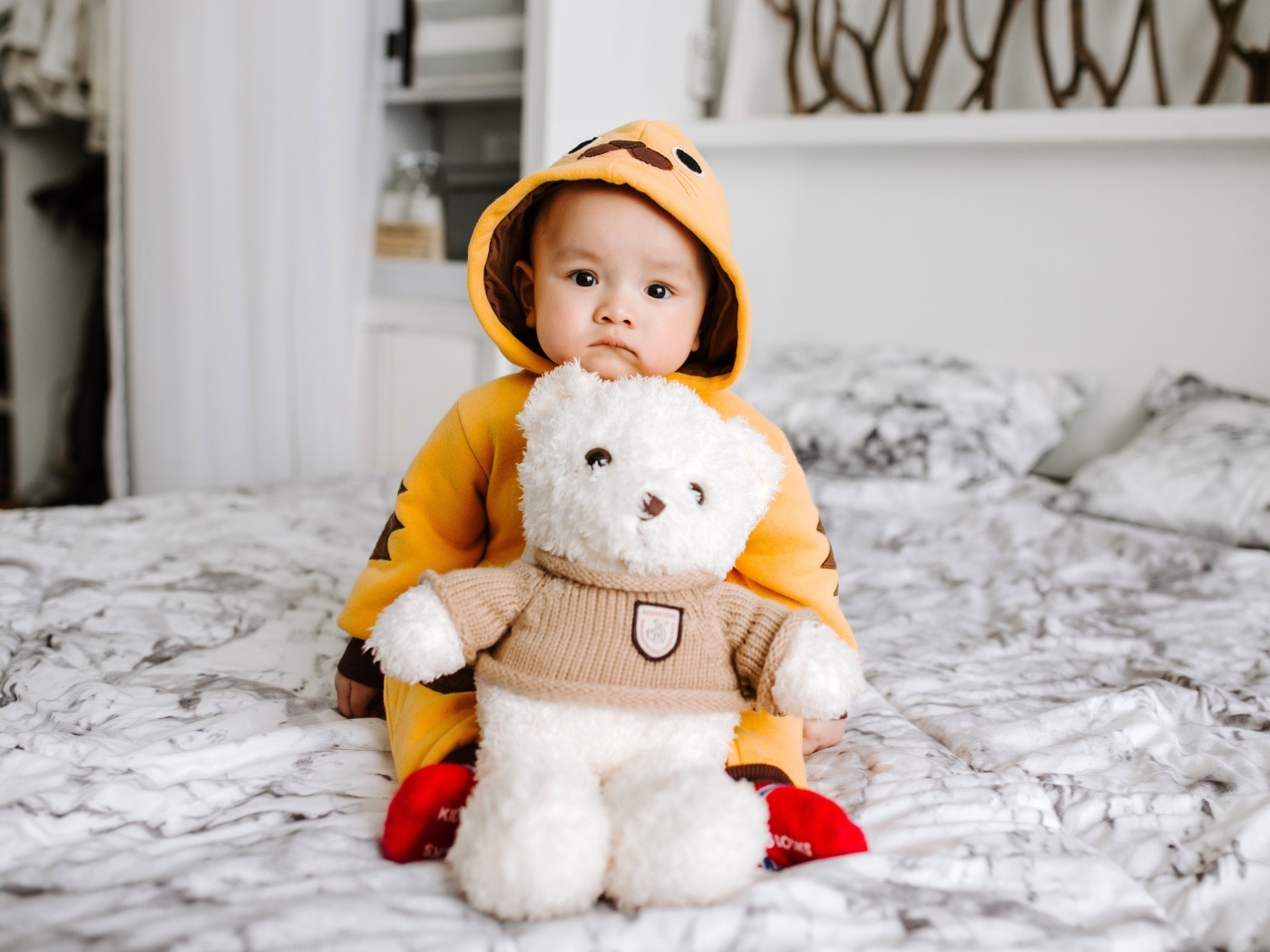 Маленький ребенок с игрушкой на кровати 