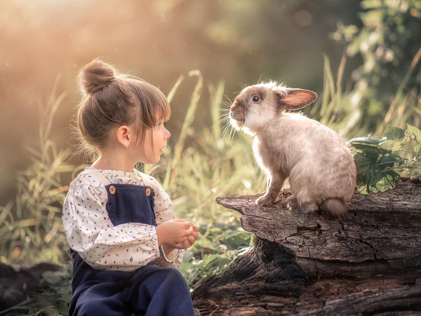 Маленькая девочка с кроликом в саду