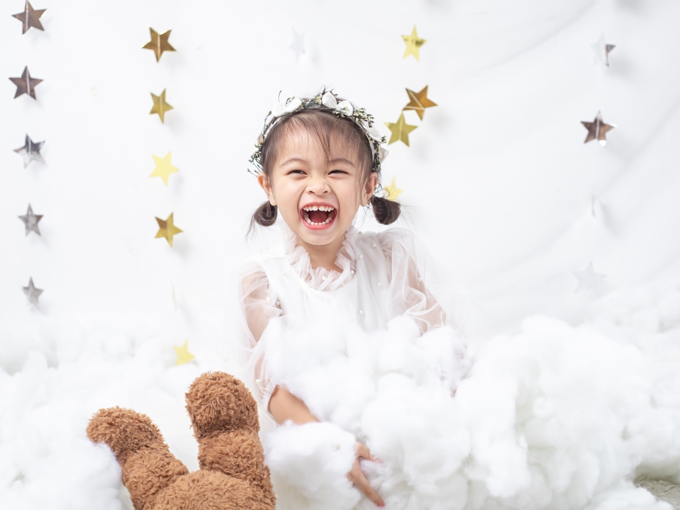 Маленькая улыбающаяся девочка азиатка в белом платье