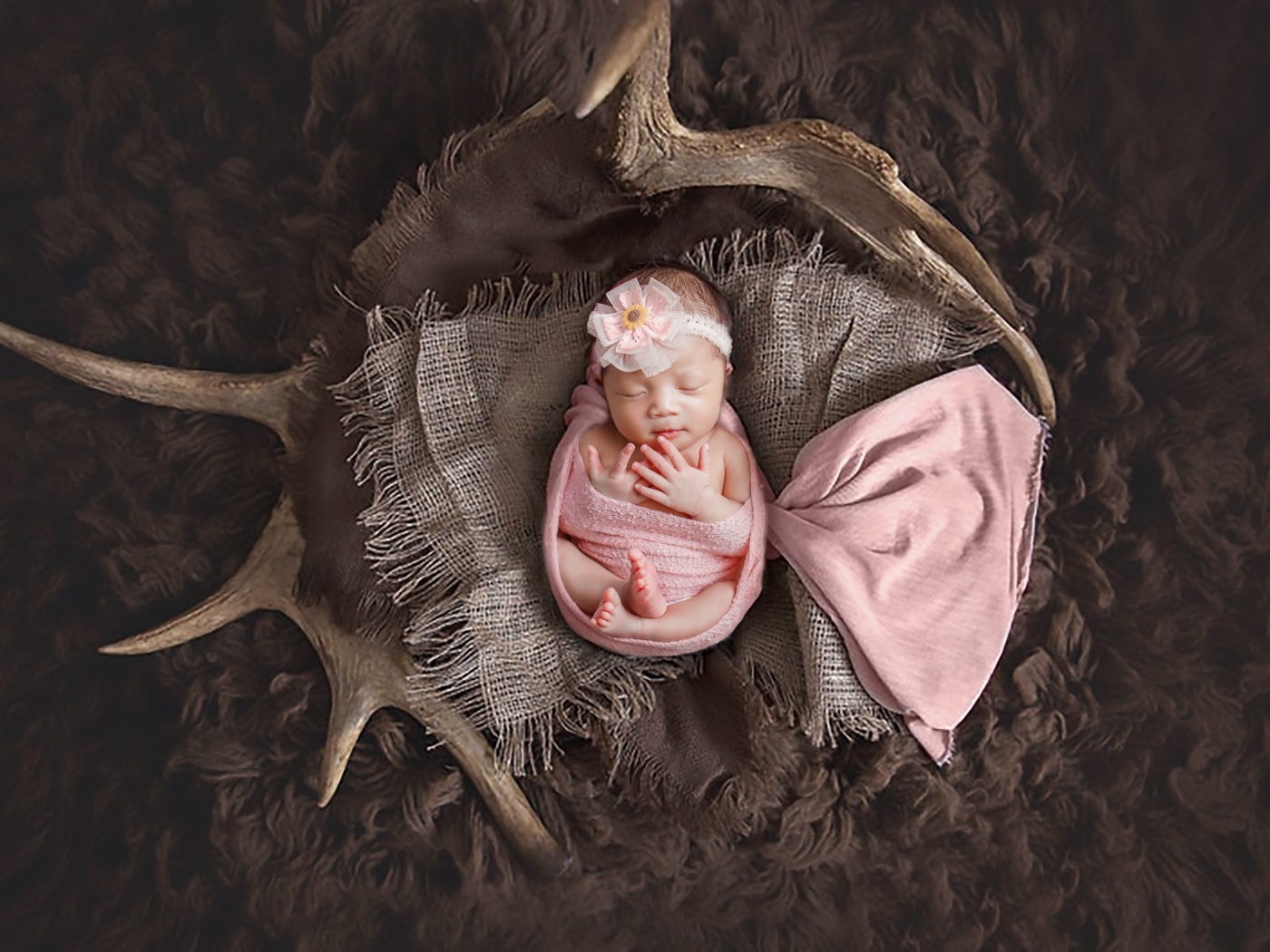 Новорожденная девочка на покрывале с рогами