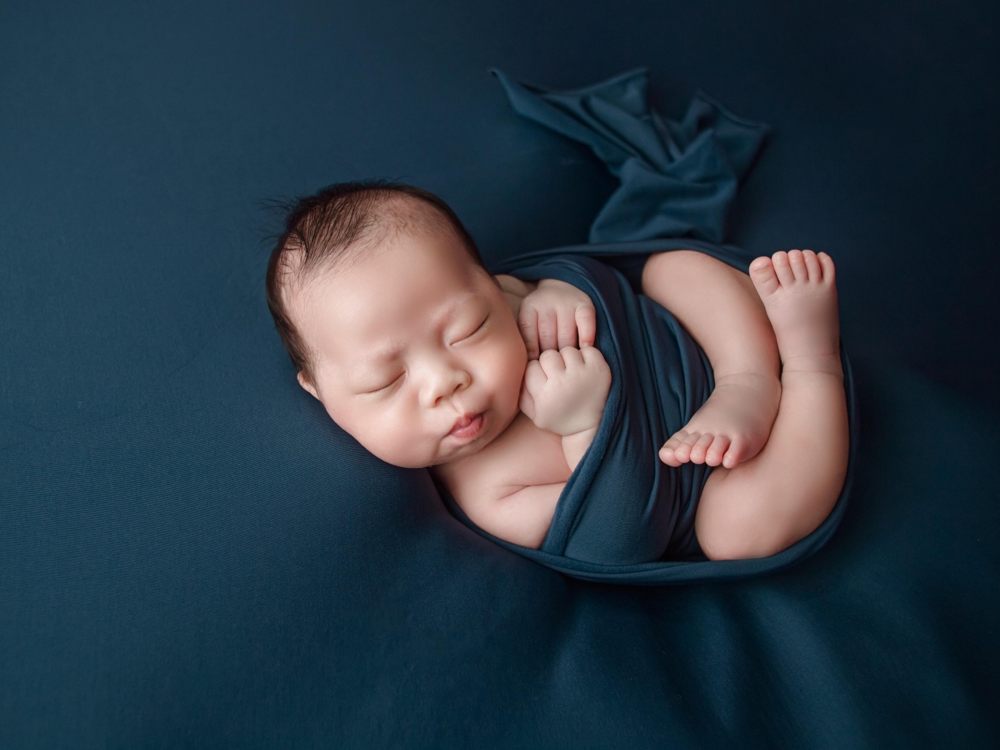 Новорожденный малыш в черном покрывале