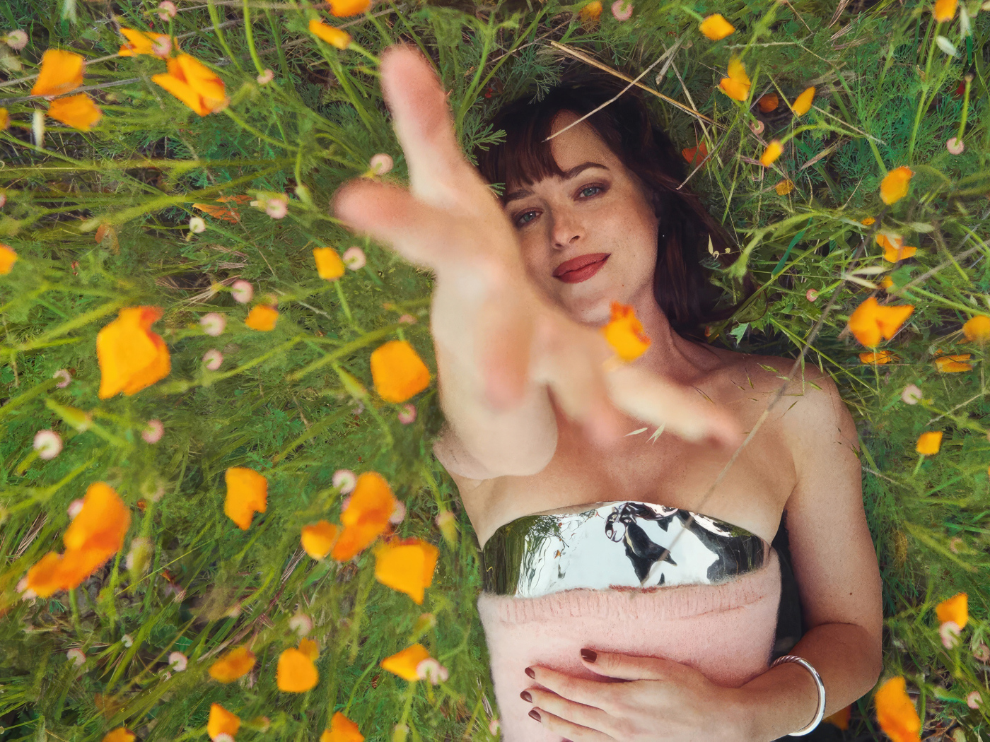 Американская актриса Дакота Джонсон лежит на траве с цветами