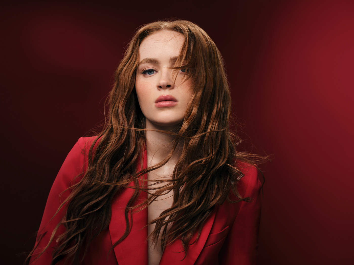 Американская актриса Сэди Синк на красном фоне