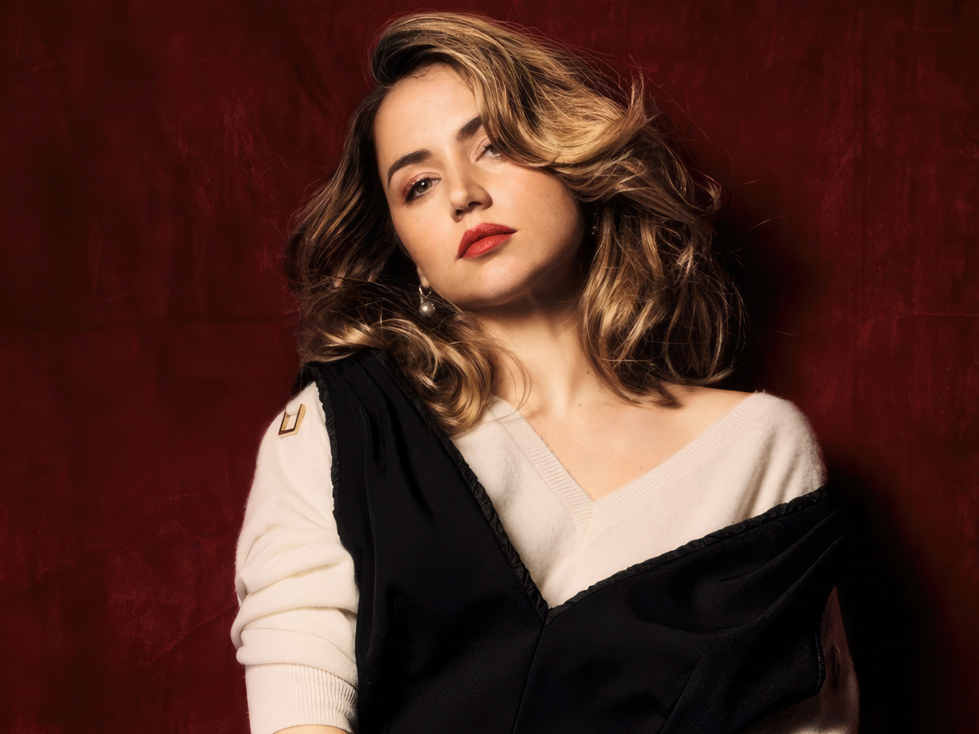 Милая актриса Ана де Армас стоит у красной стены