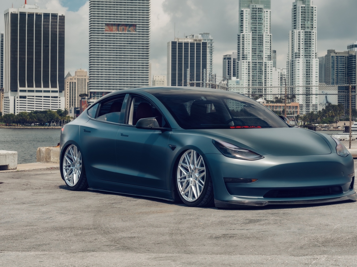 Электрокар Tesla Model 3 на фоне небоскребов