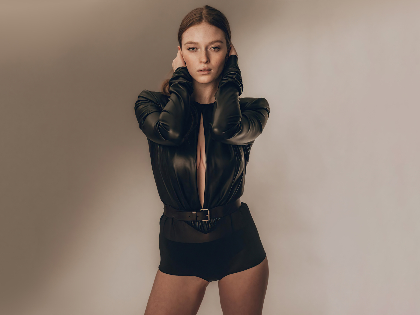 Девушка Ларсен Томпсон в черном костюме у стены