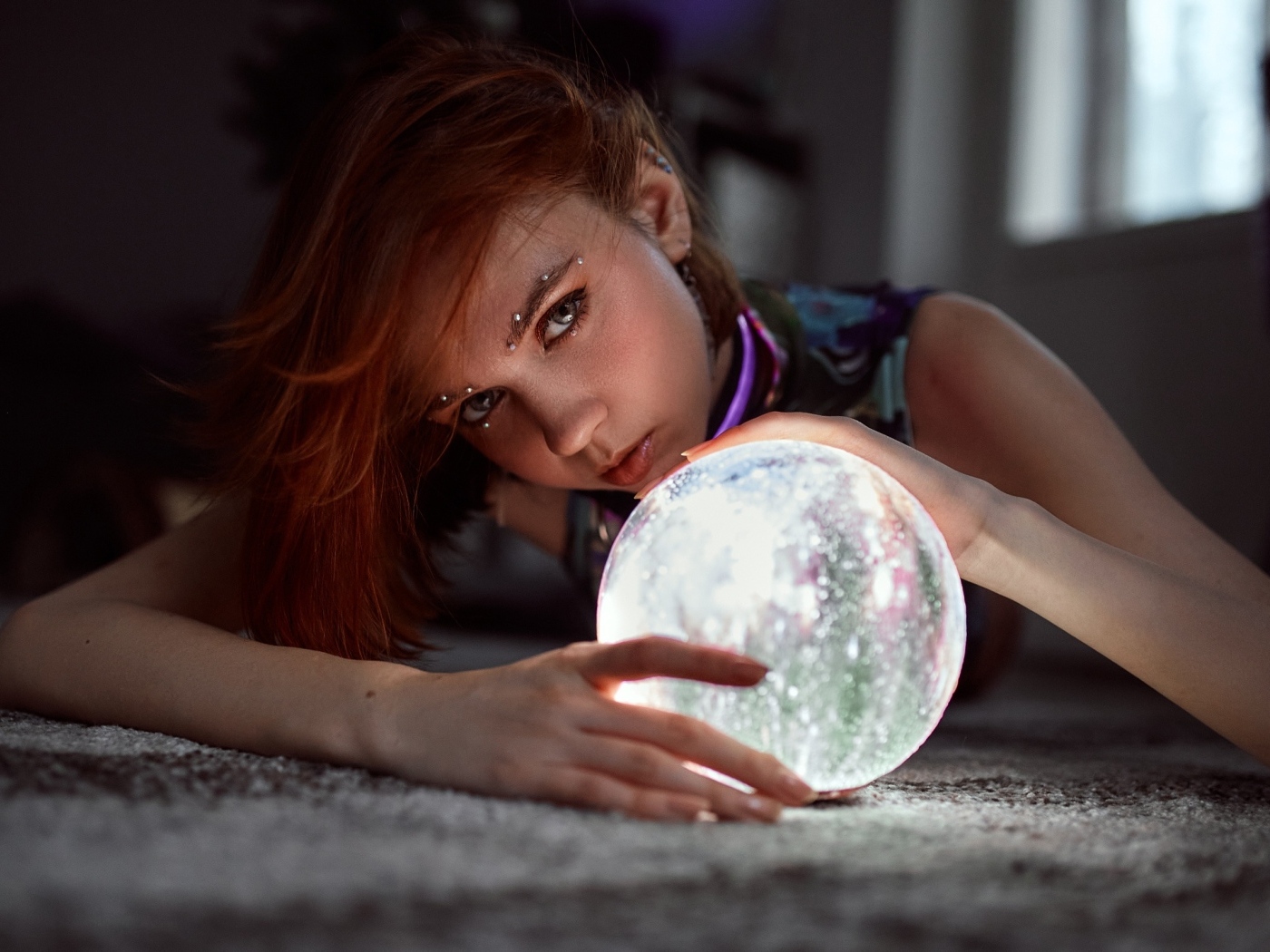 Девушка с пирсингом держит волшебный шар