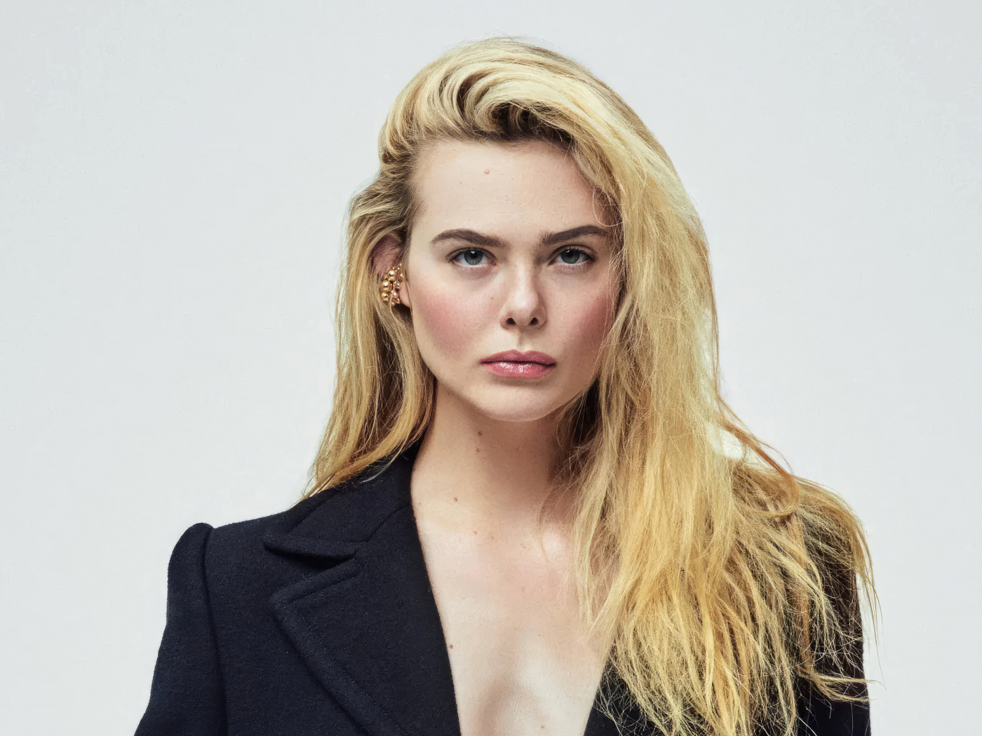 Серьезная девушка актриса  Эль Фэннинг на сером фоне