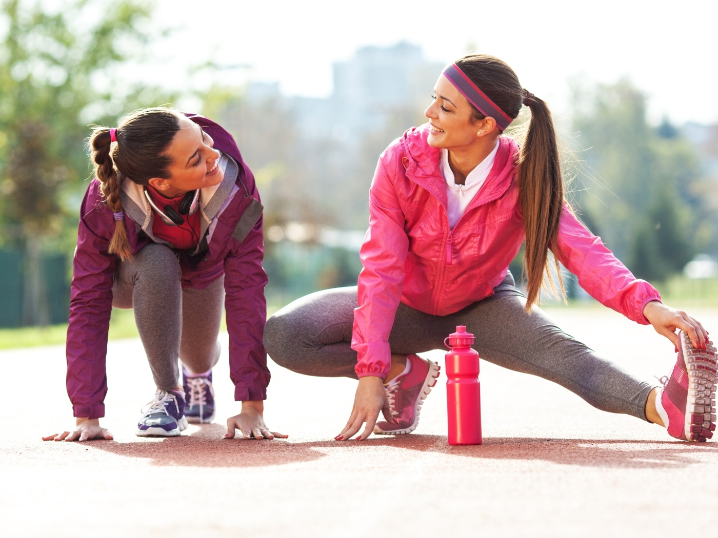 Две спортивные девушки делают растяжку 
