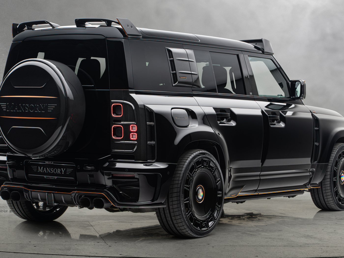 Вид сзади на черный автомобиль Mansory Land Rover Defender 110 Black Edition 2024 года