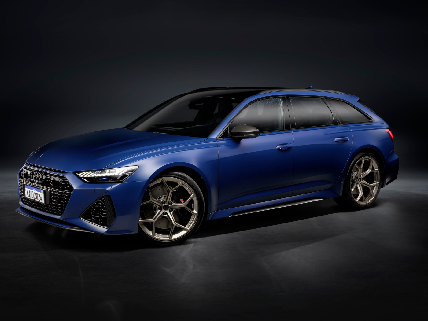 Синий автомобиль Audi RS 6 Avant Legacy 2024 года на сером фоне