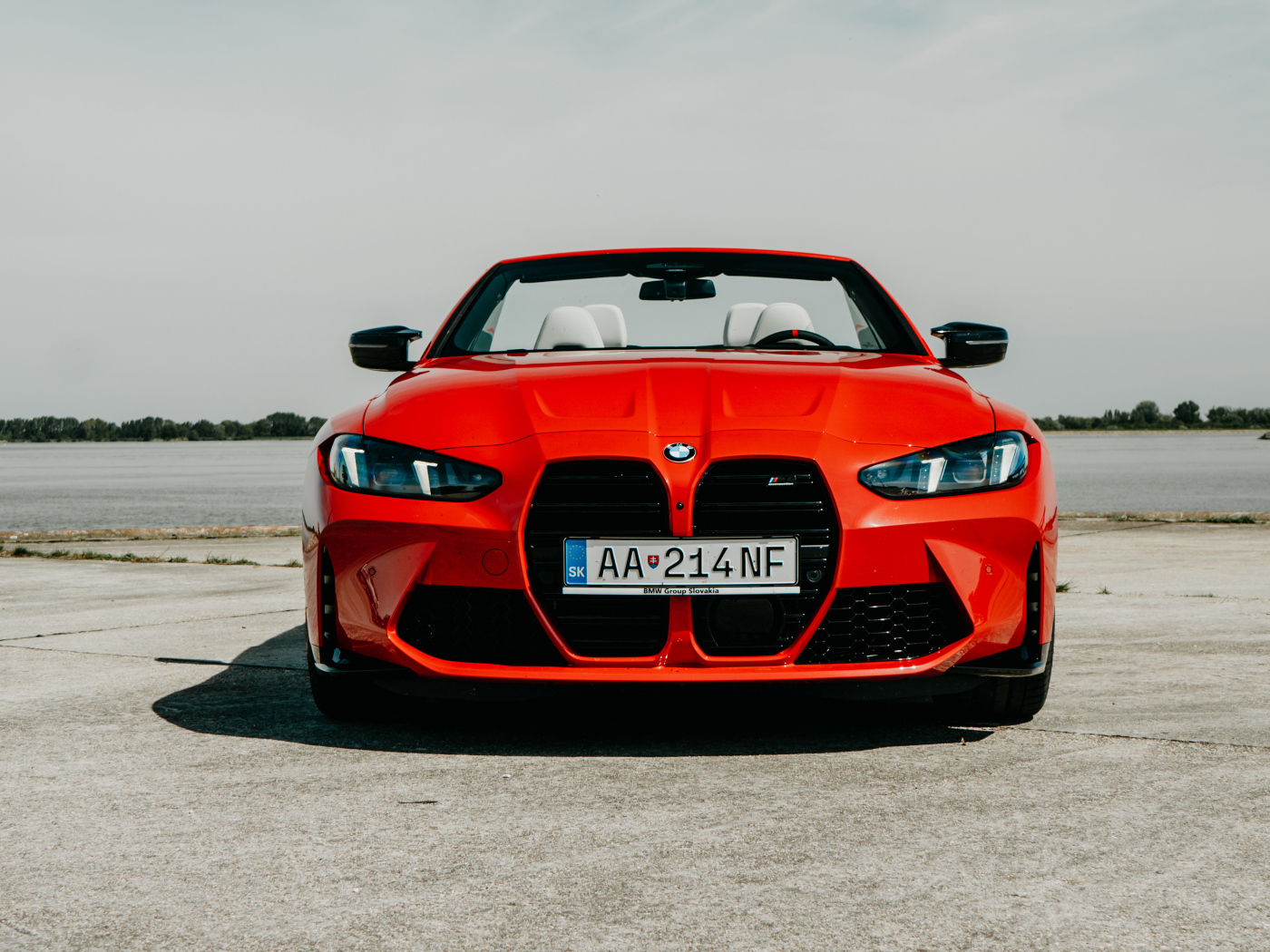 Вид спереди на красный автомобиль BMW M4 Competition M xDrive Cabrio 2024 года