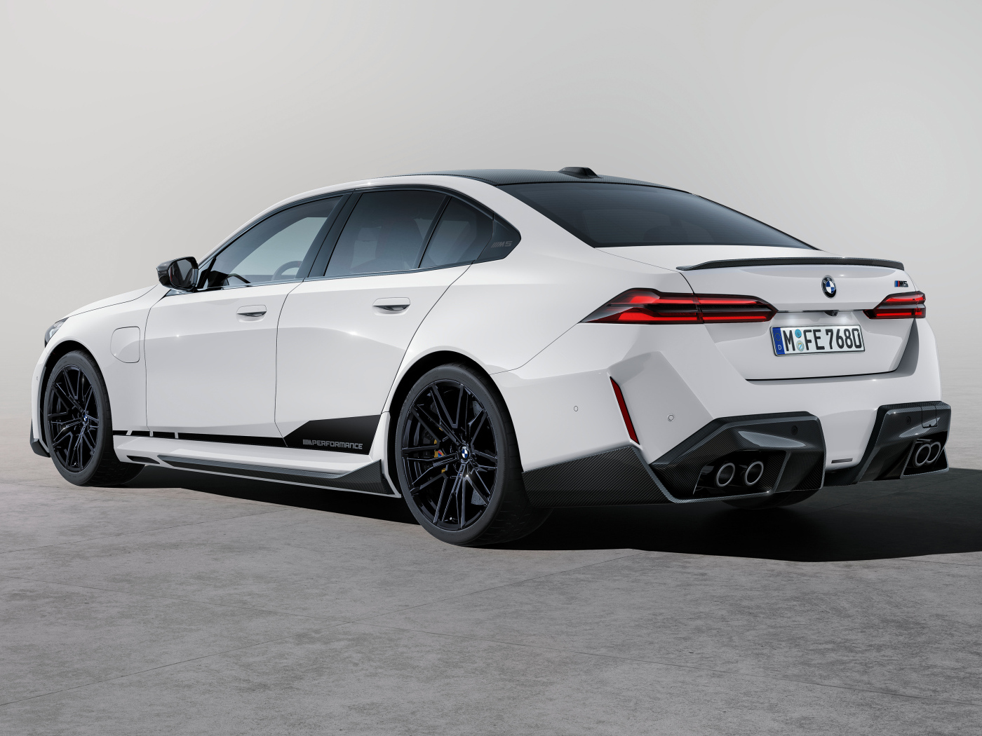 Вид сзади на белый автомобиль BMW M5 M