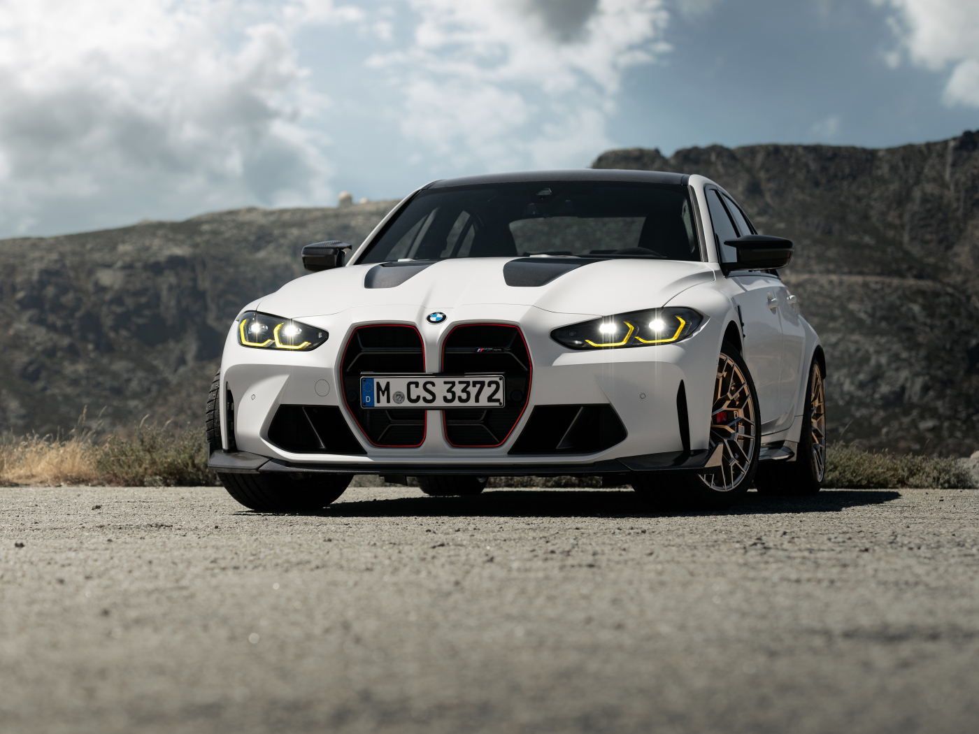 Белый автомобиль BMW M3 CS  на фоне гор