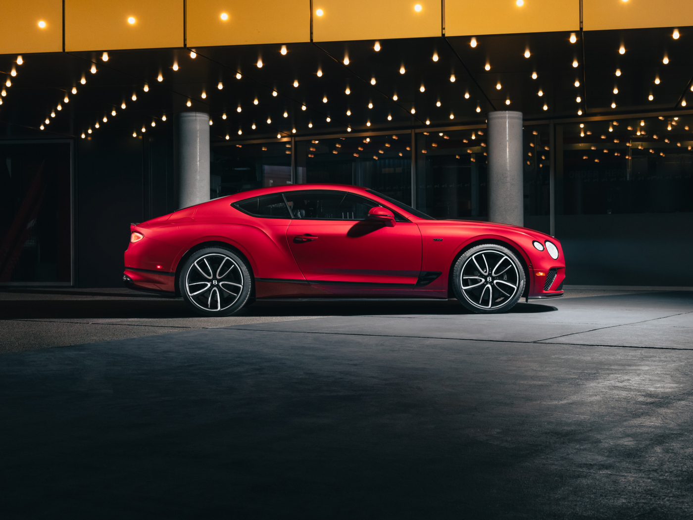 Вид сбоку на красный автомобиль Bentley Continental GT V8 Edition 2024 года