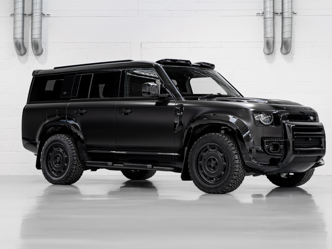 Большой черный автомобиль Land Rover Defender Widetrack 2024 года