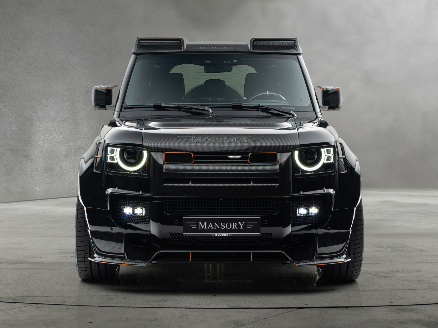 Вид спереди на черный автомобиль Mansory Land Rover Defender 110 Black Edition 2024 года