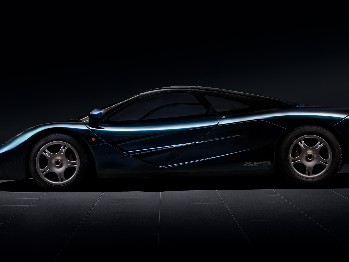 Вид сбоку на черный дорогой автомобиль McLaren F1