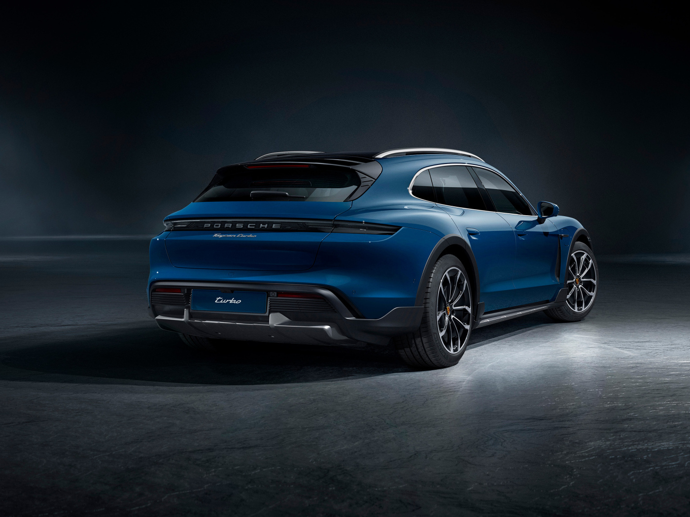 Синий автомобиль Porsche Taycan Turbo вид сзади