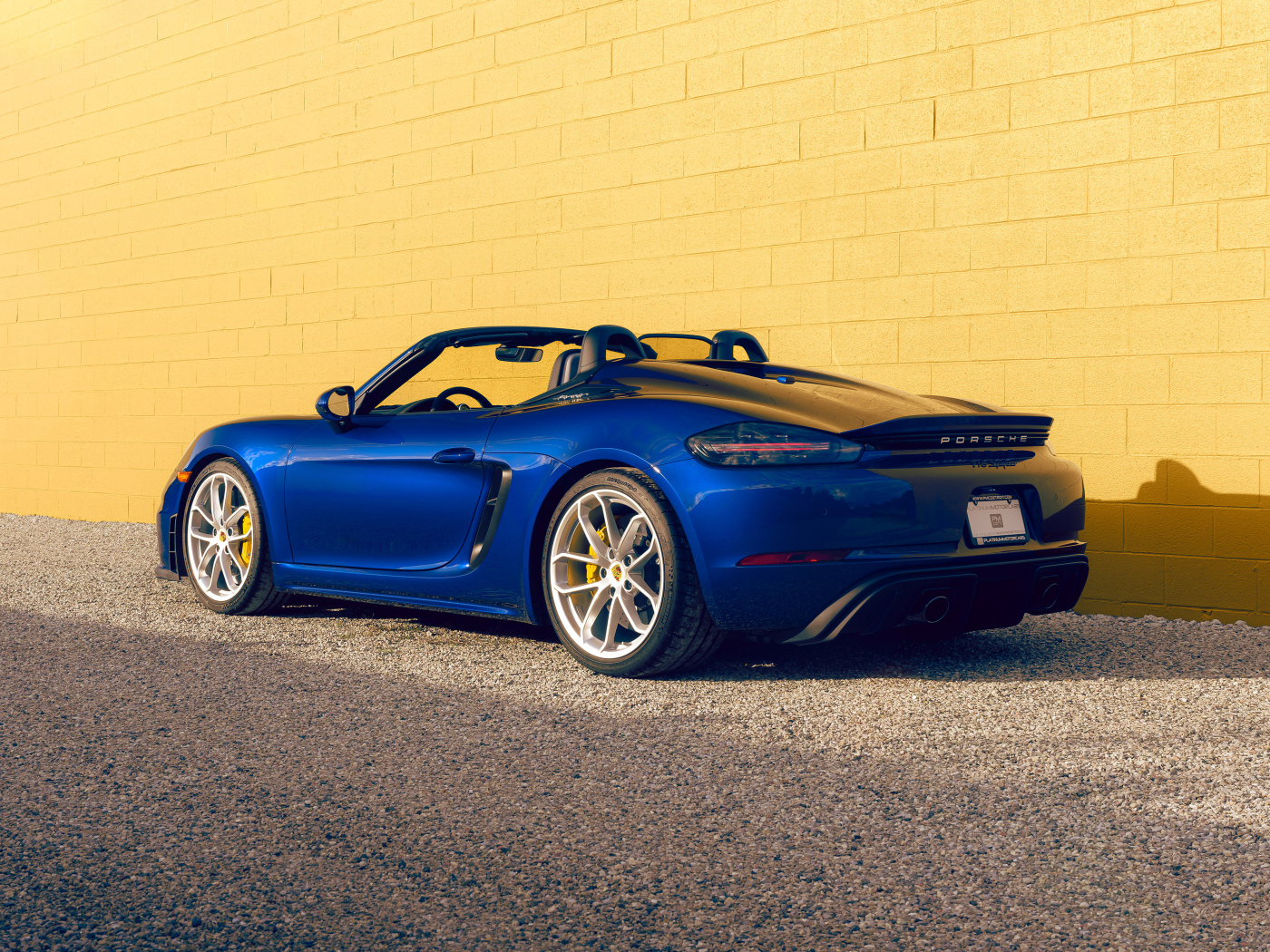 Вид сзади на синий автомобиль Porsche 718 Spyder