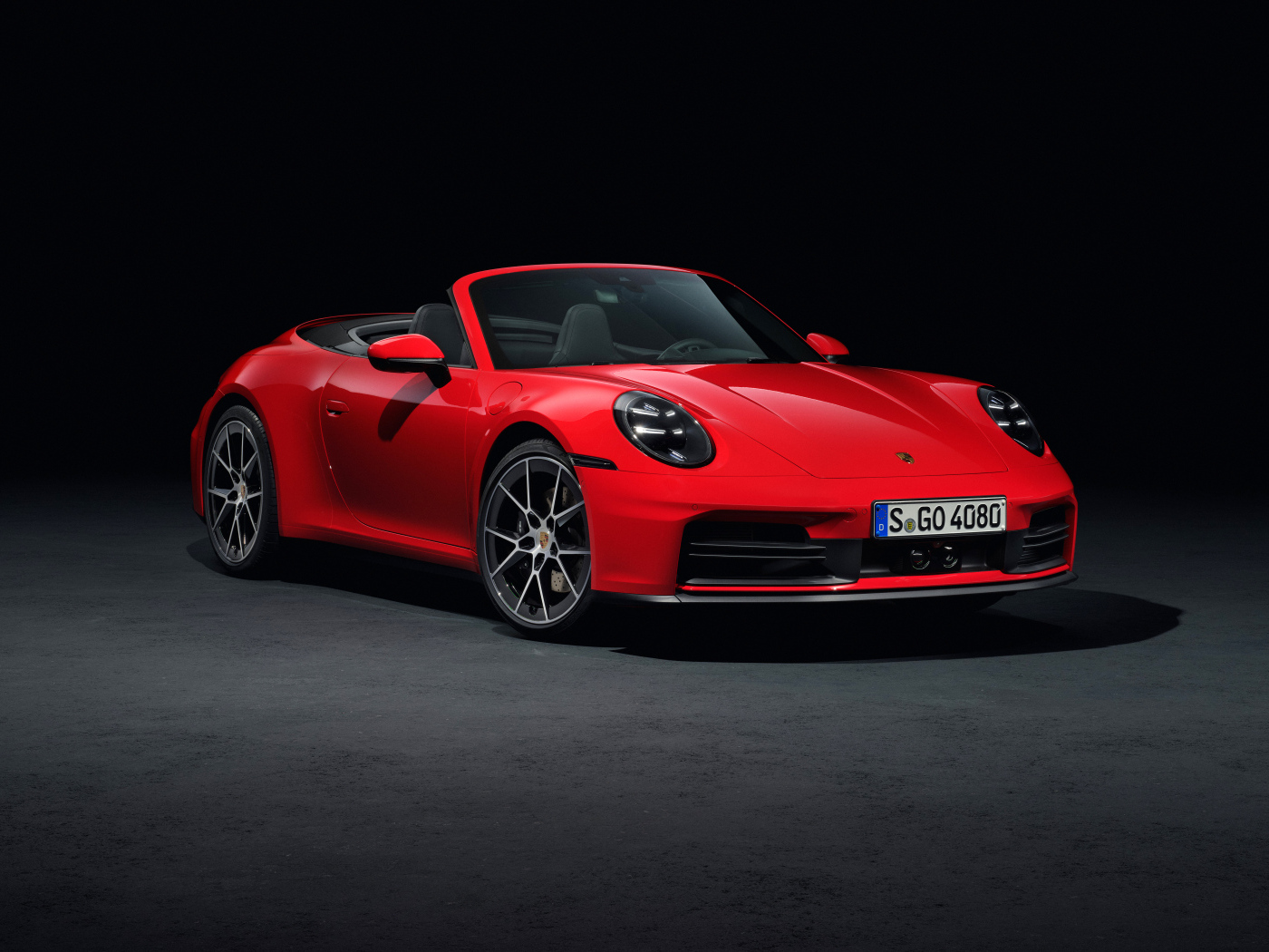 Красный автомобиль Porsche 911 Carrera Cabriolet 2024 года