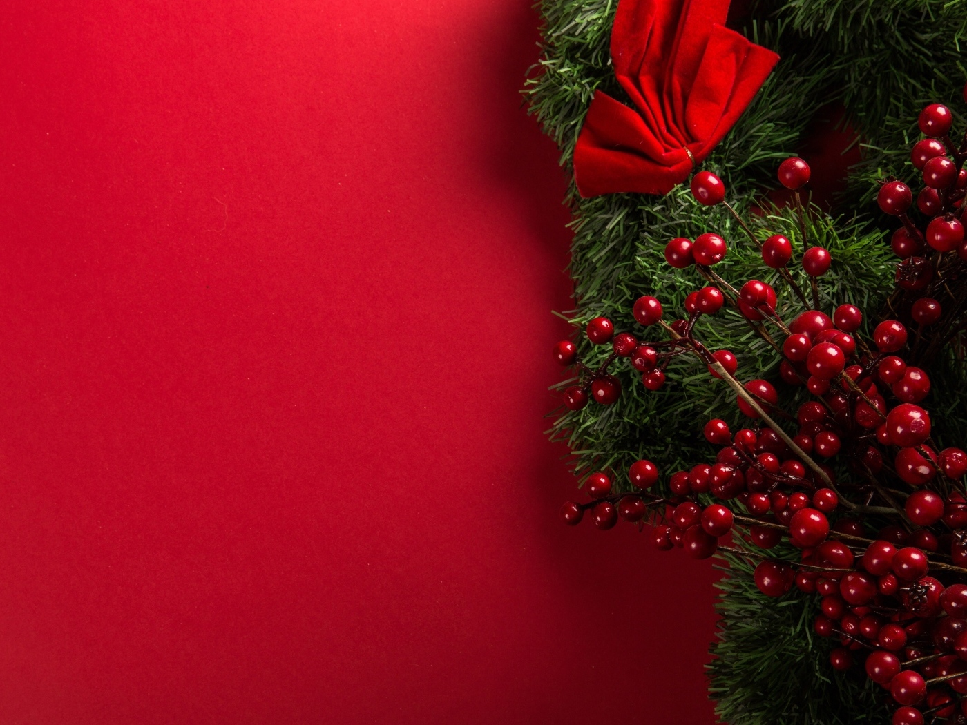 Красный фон с еловой веткой с ягодами