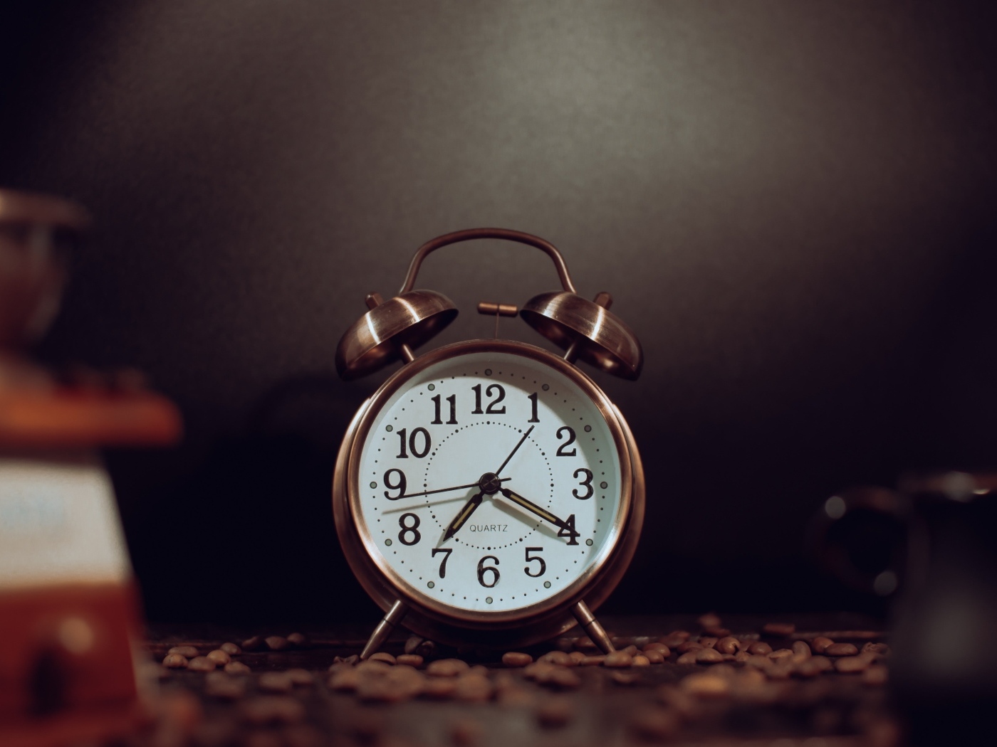 Будильник на столе с зернами кофе